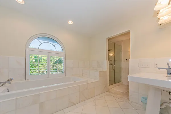 a spacious bathroom with a tub shower and sink