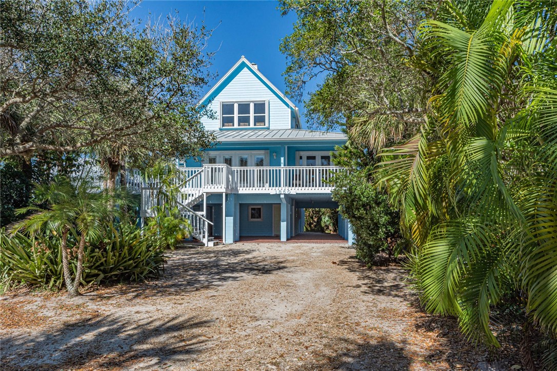 1850 East Sandpiper Road Vero Beach, FL 32963 - Photo 2 of 36 a front view of a house with a garden