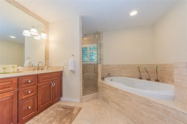 a spacious bathroom with a tub double sink and mirror