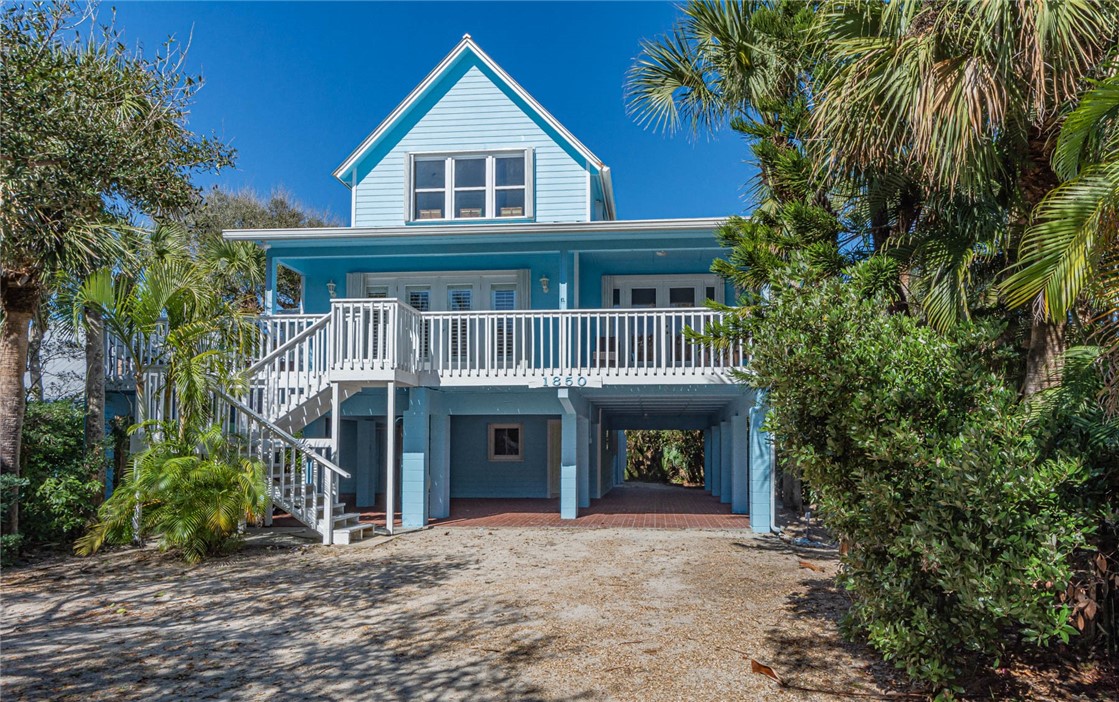 1850 East Sandpiper Road Vero Beach, FL 32963 - Photo 3 of 36 a front view of a house with a yard and trees