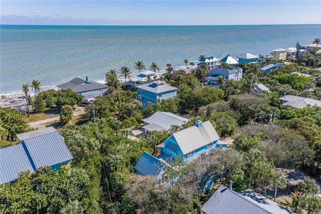 an aerial view of a house with a yard and lake view