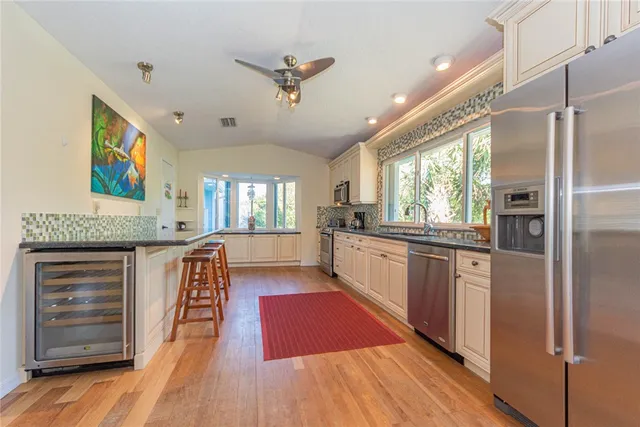 a large kitchen with stainless steel appliances granite countertop a refrigerator and a sink