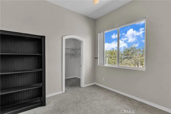a view of an empty room with closet and a window