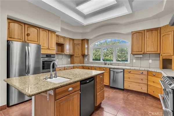 a kitchen with granite countertop a sink window and cabinets