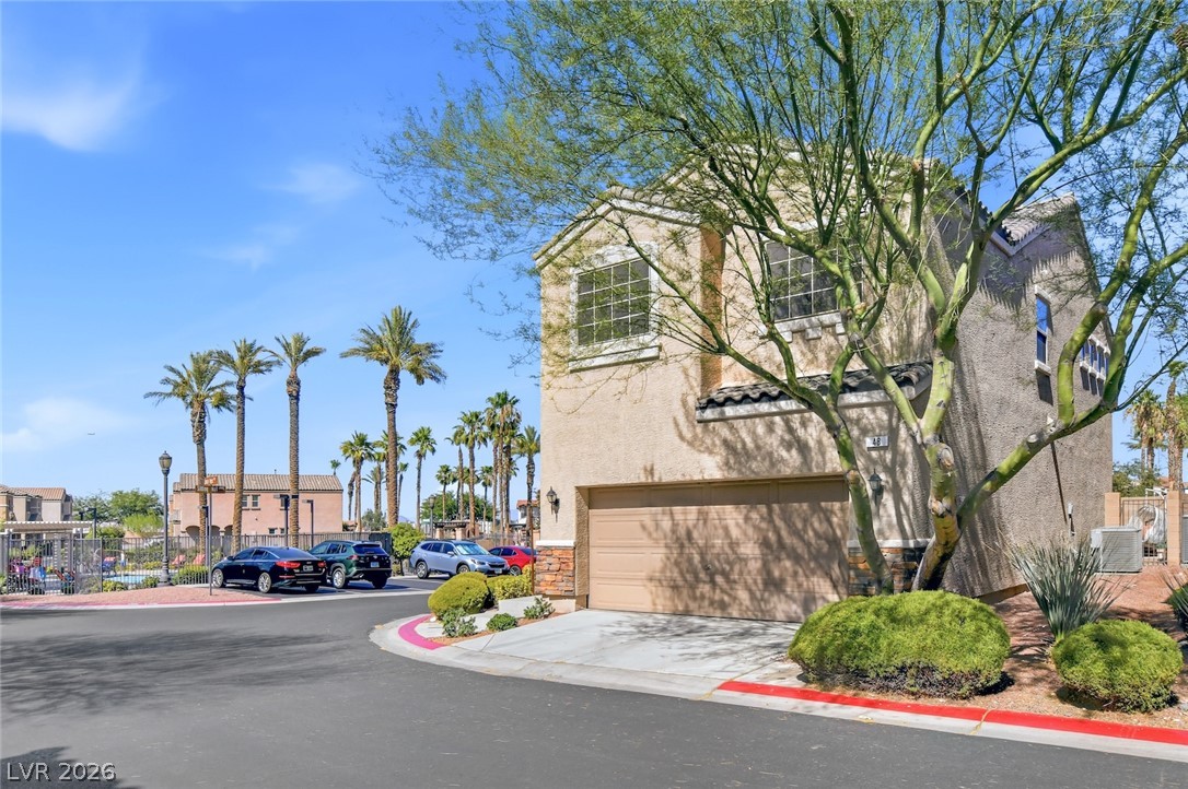 48 Jasmine Point Street Henderson, NV 89074 - Photo 59 of 62 A desert-friendly facade, with palm trees lining the distant neighborhood.