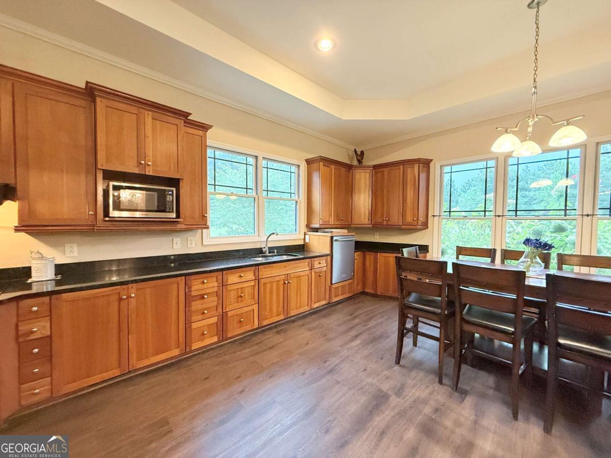 2415 Elko Road Elko, GA 31025 - Photo 10 of 85 a kitchen with stainless steel appliances granite countertop wooden cabinets a stove a sink a dining table and chairs
