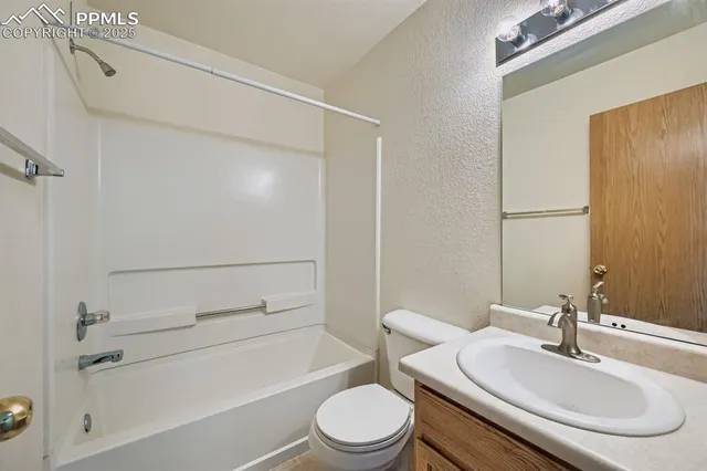 a bathroom with a granite countertop sink toilet a mirror and shower