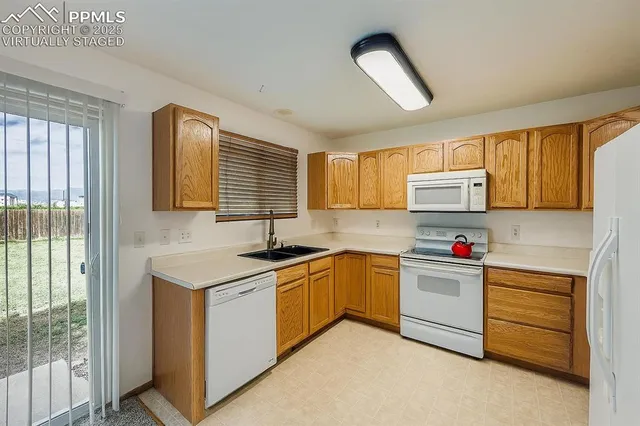 a kitchen with granite countertop a sink stainless steel appliances and cabinets