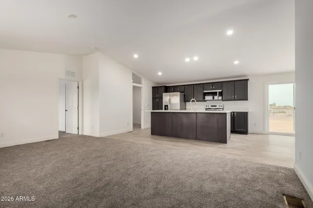 a large kitchen with a sink and dishwasher a refrigerator with wooden cabinets