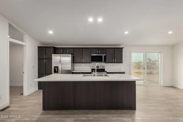 a kitchen with stainless steel appliances granite countertop a sink a stove and a refrigerator