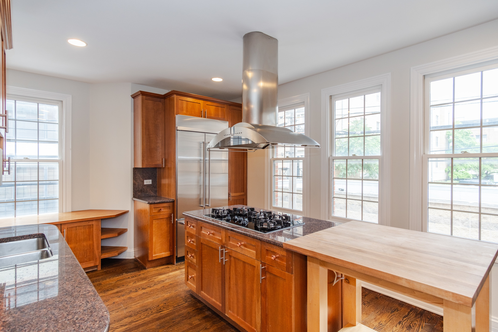 24 North Ada Street, Unit I Chicago, IL 60607 - Photo 9 of 29 a kitchen with stainless steel appliances granite countertop a stove a sink dishwasher and white cabinets with wooden floor