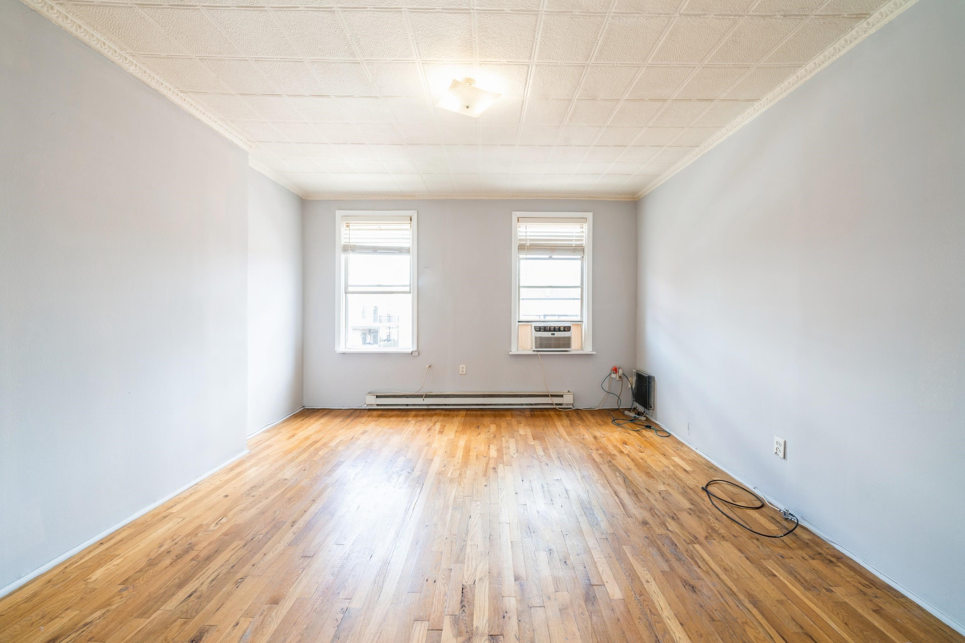 407 4th Street, Unit 4R (6) Hoboken, NJ 07030 - Photo 1 of 17 an empty room with wooden floor and windows