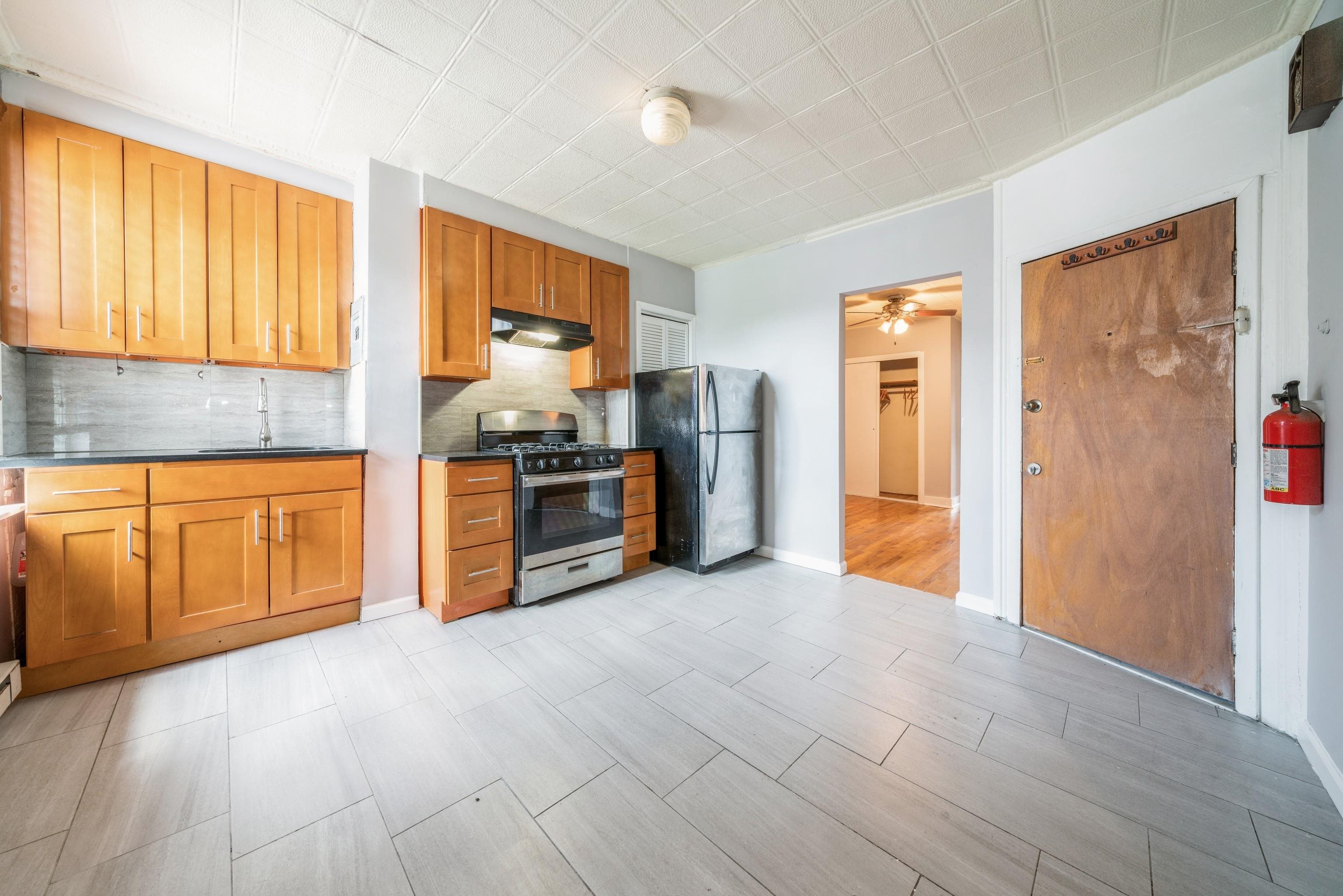 407 4th Street, Unit 4R (6) Hoboken, NJ 07030 - Photo 5 of 17 a view of a kitchen with furniture and an empty room
