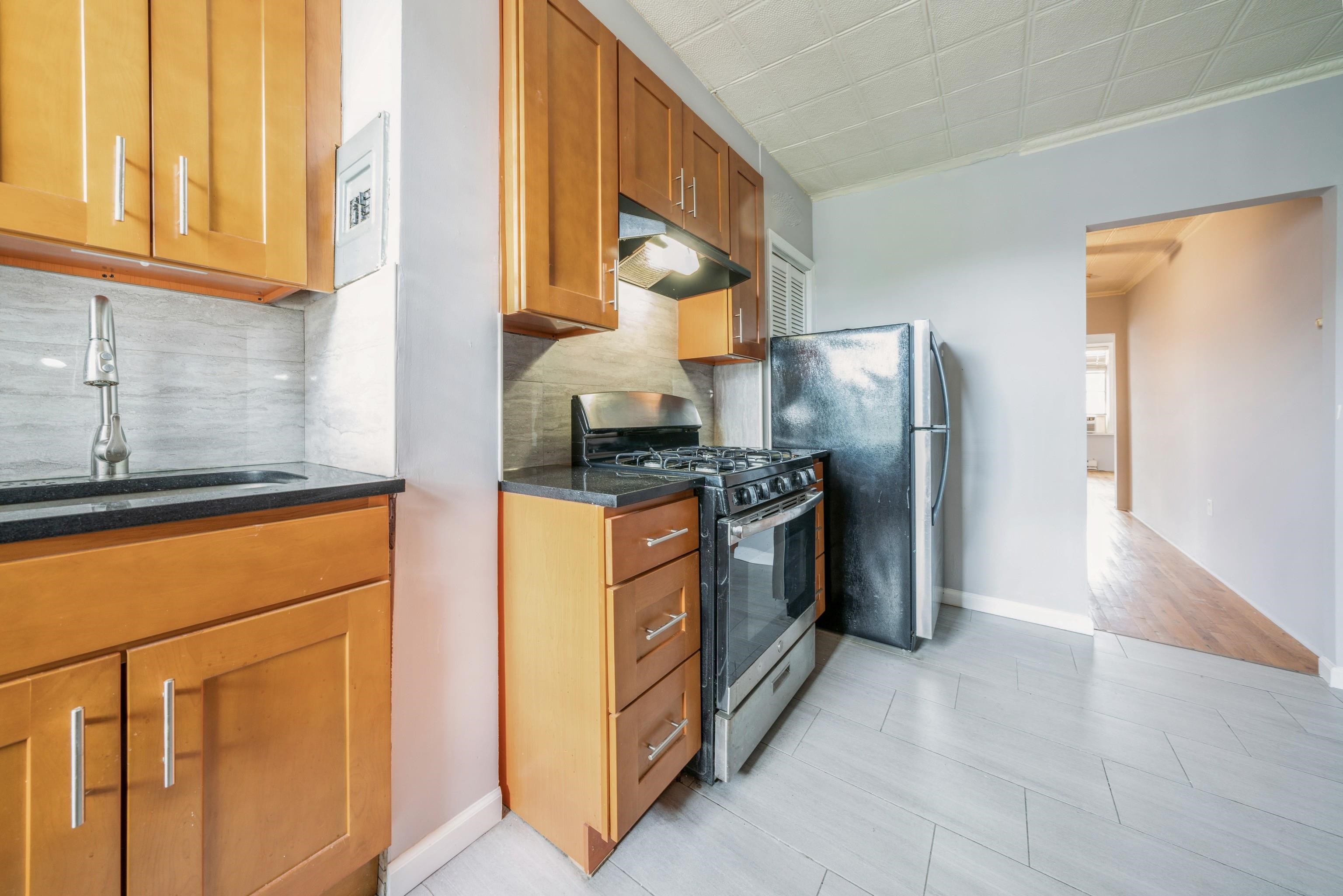 407 4th Street, Unit 4R (6) Hoboken, NJ 07030 - Photo 6 of 17 a kitchen with stainless steel appliances granite countertop a refrigerator a stove and a sink