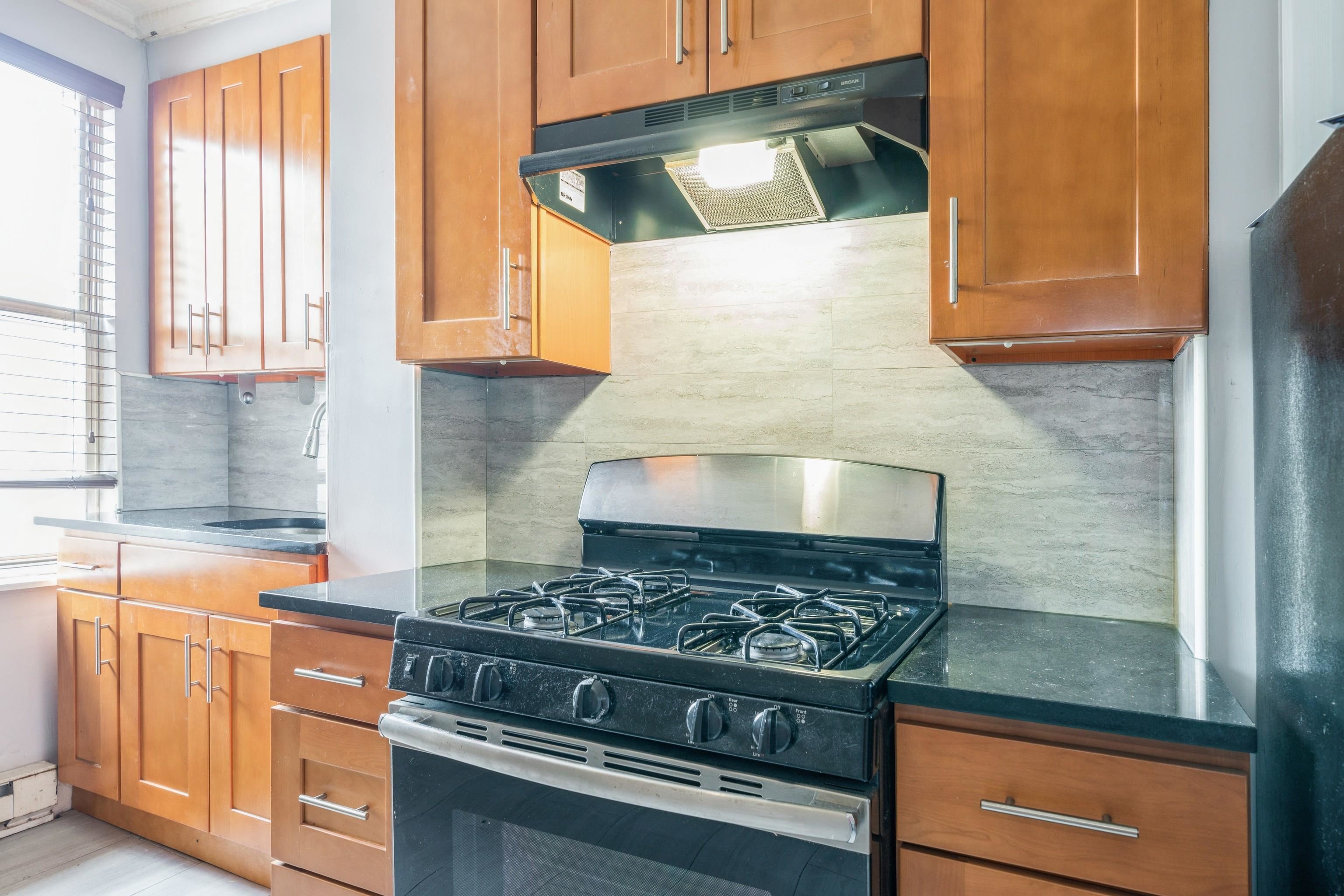 407 4th Street, Unit 4R (6) Hoboken, NJ 07030 - Photo 7 of 17 a kitchen with stainless steel appliances granite countertop a stove and a microwave