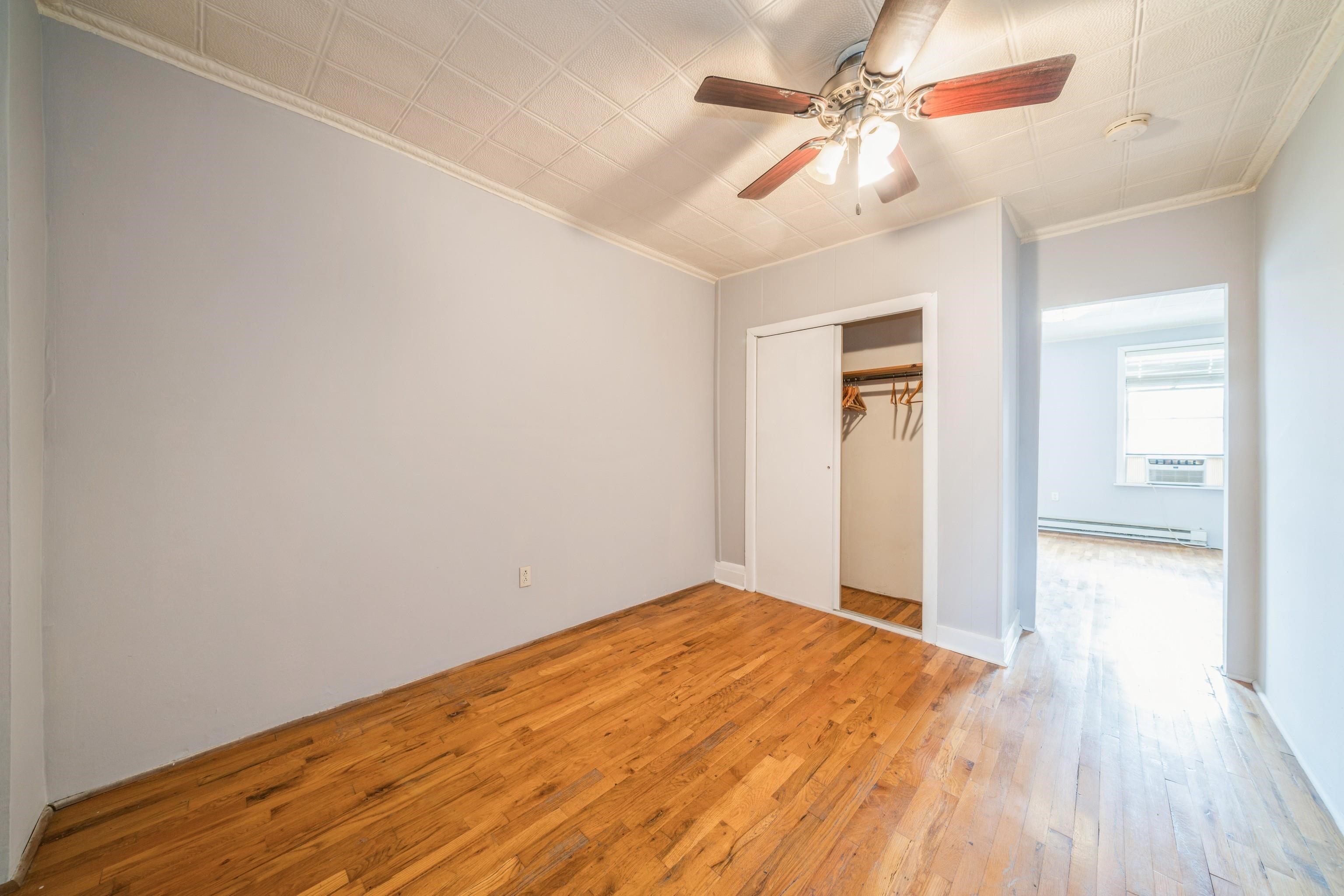 407 4th Street, Unit 4R (6) Hoboken, NJ 07030 - Photo 10 of 17 a view of a big room with wooden floor and a chandelier fan in a room