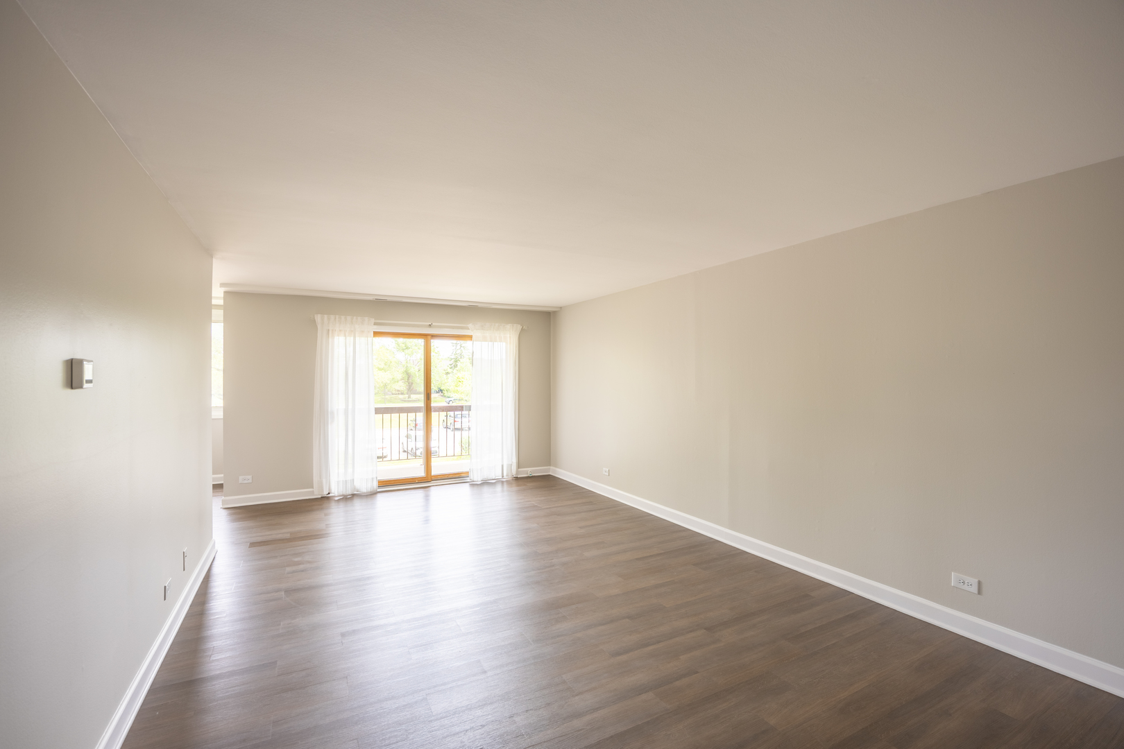 450 Raintree Court, Unit 2B Glen Ellyn, IL 60137 - Photo 2 of 28 a view of an empty room with wooden floor and window