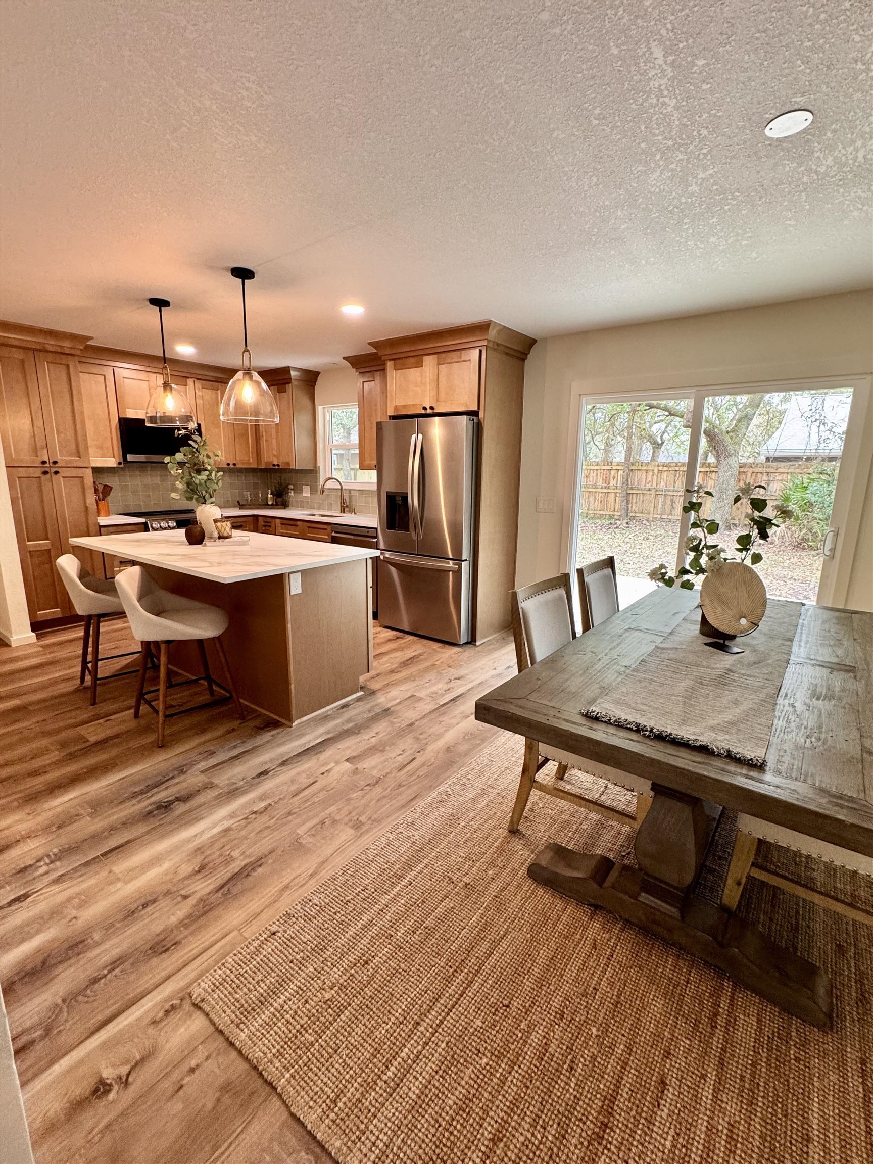 226 Jasmine Road St. Augustine, FL 32086 - Photo 5 of 20 a room with stainless steel appliances kitchen island granite countertop a table chairs and a wooden floor