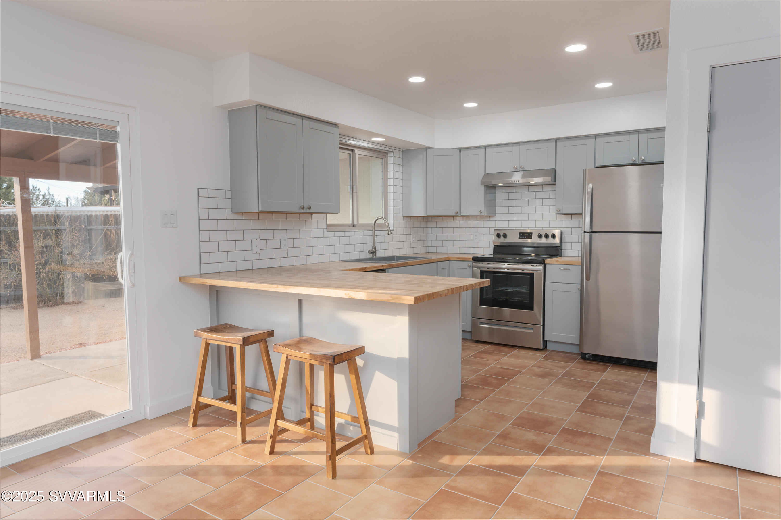 4875 East Mallard Drive Rimrock, AZ 86335 - Photo 20 of 36 a kitchen with stainless steel appliances granite countertop a stove a sink a microwave a refrigerator and white cabinets with wooden floor
