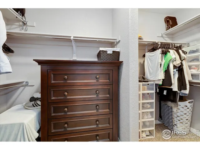 a view of walk in closet with clothes and shoes