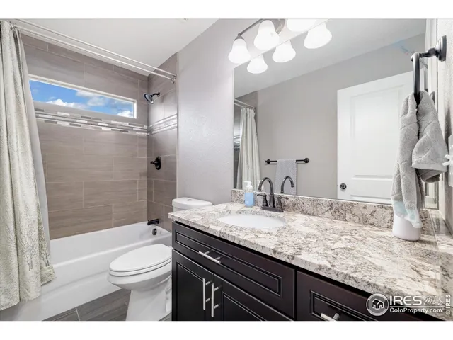 a bathroom with a granite countertop sink toilet mirror and shower