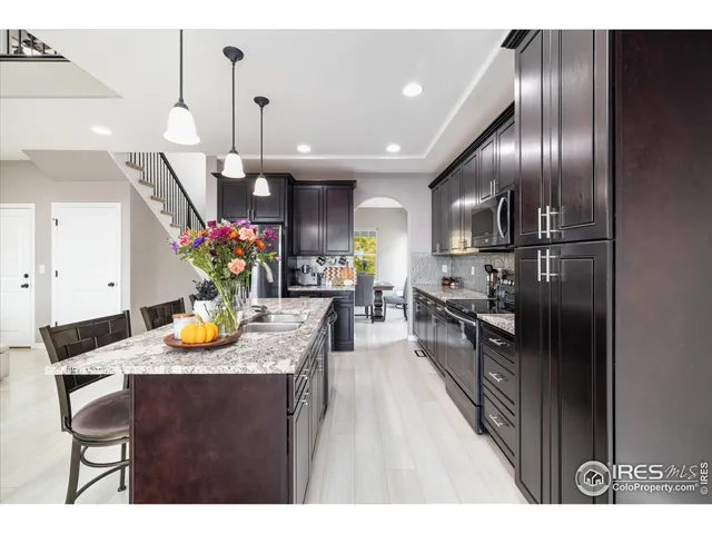 a kitchen with stainless steel appliances granite countertop a sink refrigerator and cabinets