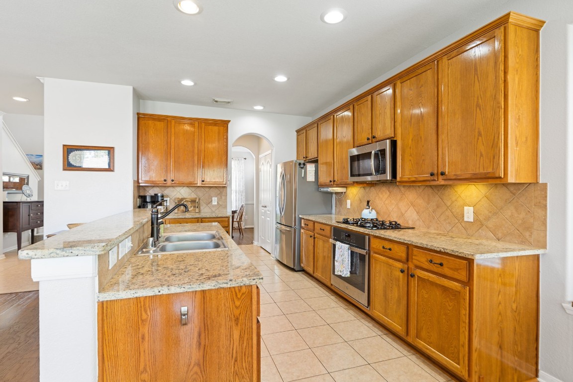 5318 Wisteria Brook Lane Spring, TX 77379 - Photo 14 of 50 a kitchen with stainless steel appliances granite countertop a stove a sink dishwasher and a refrigerator