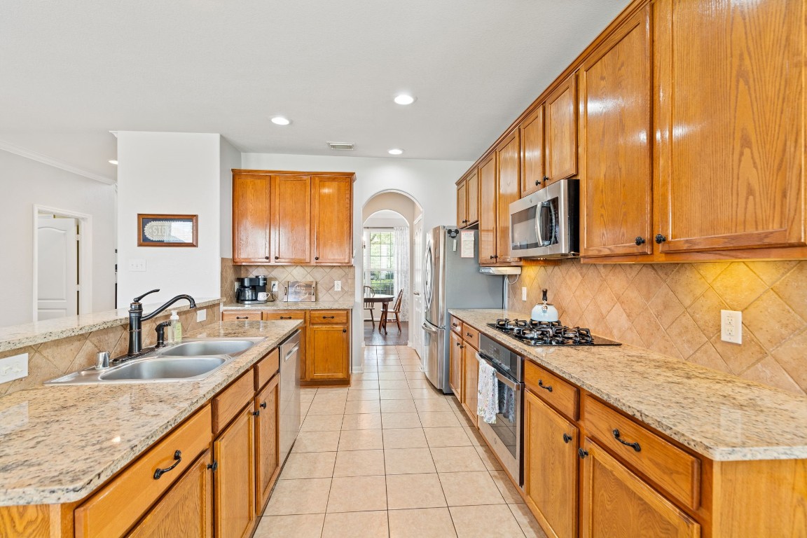 5318 Wisteria Brook Lane Spring, TX 77379 - Photo 15 of 50 a kitchen with stainless steel appliances granite countertop a sink stove and cabinets