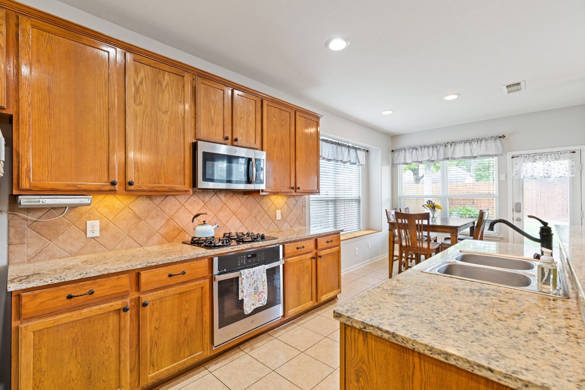 5318 Wisteria Brook Lane Spring, TX 77379 - Photo 17 of 50 a kitchen with stainless steel appliances granite countertop a sink stove and microwave