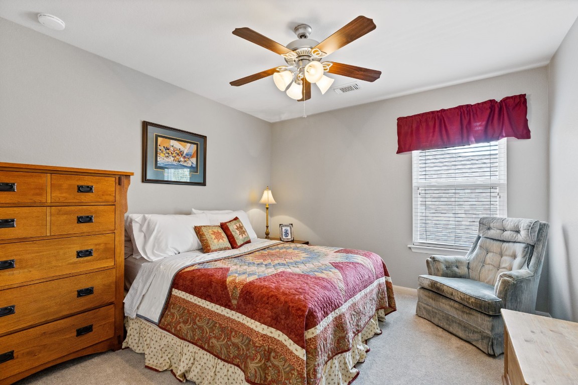 5318 Wisteria Brook Lane Spring, TX 77379 - Photo 31 of 50 a bedroom with a bed and a chandelier