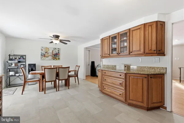 a kitchen with stainless steel appliances granite countertop a stove top oven a dining table and chairs with wooden floor
