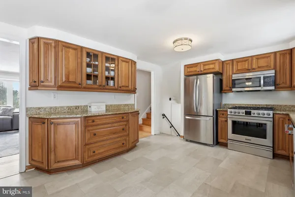 a kitchen with stainless steel appliances granite countertop a refrigerator and a stove top oven
