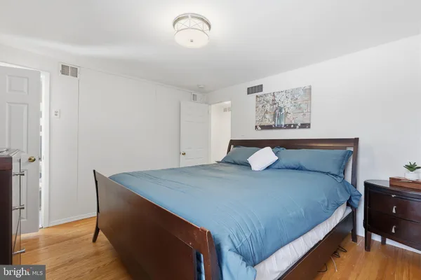 a bedroom with a bed and a painting on the wall