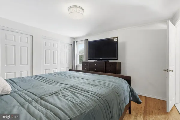 a bedroom with a bed and a flat tv screen on wall