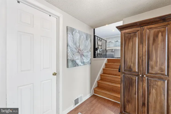 a view of a hallway with wooden floor and entryway