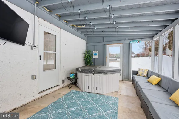 a living room with stainless steel appliances granite countertop a couch and a flat screen tv