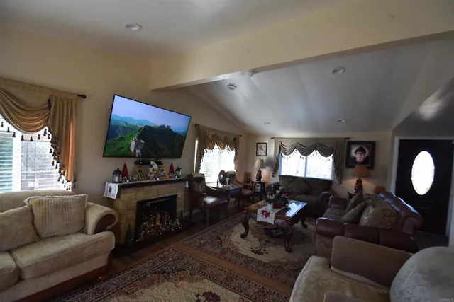 a living room with furniture a fireplace and a flat screen tv