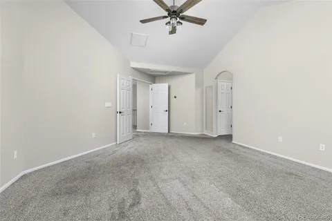 an empty room with chandelier fan