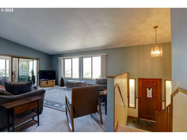 a living room with furniture a window and a flat screen tv