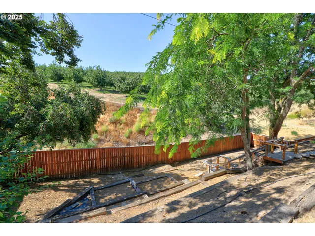 a view of backyard with wooden fence