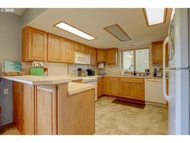 a kitchen with stainless steel appliances kitchen island granite countertop a refrigerator sink and cabinets