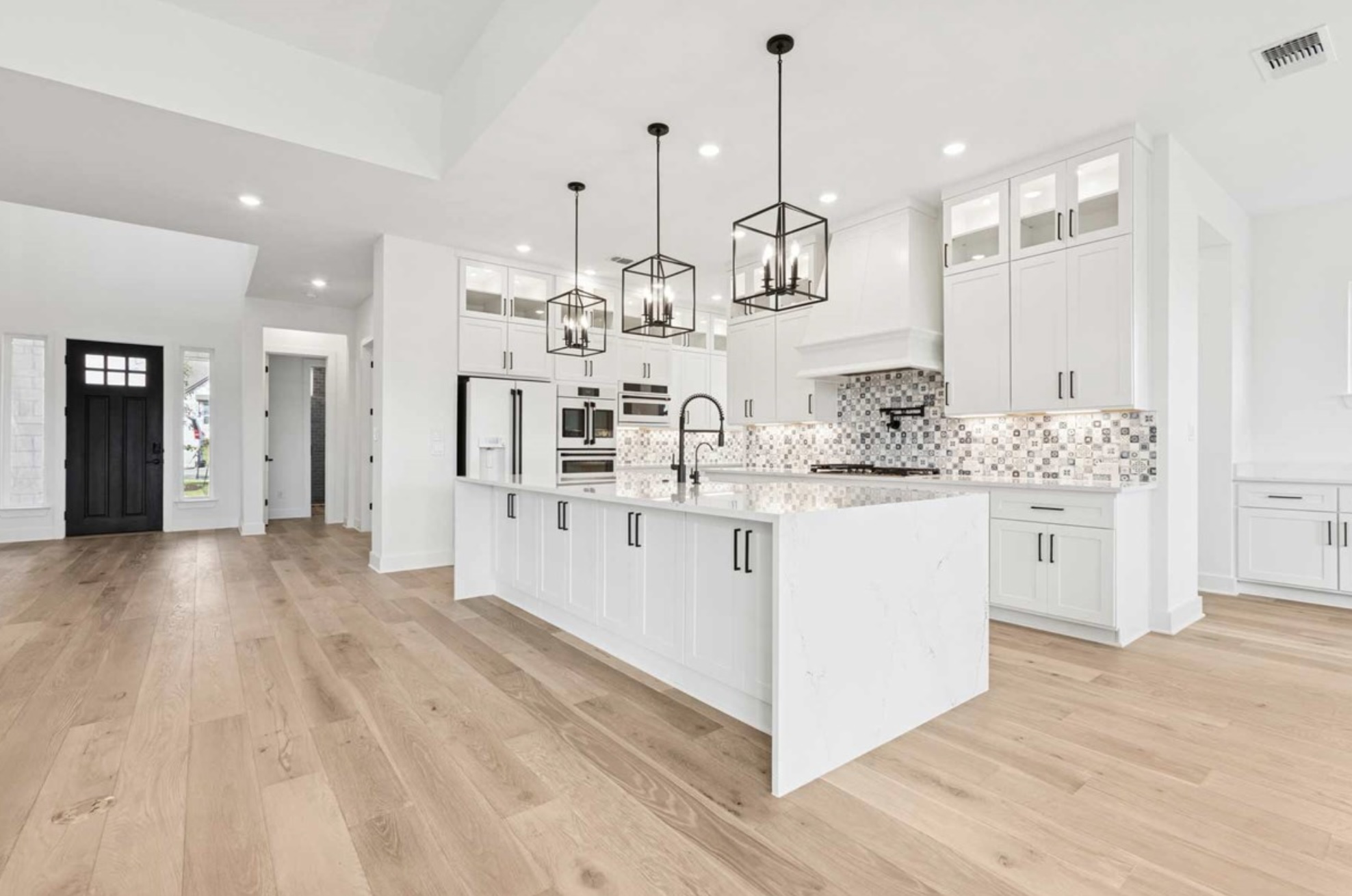 439 Vail River Road Dripping Springs, TX 78620 - Photo 3 of 20 a large white kitchen with kitchen island white cabinets and stainless steel appliances