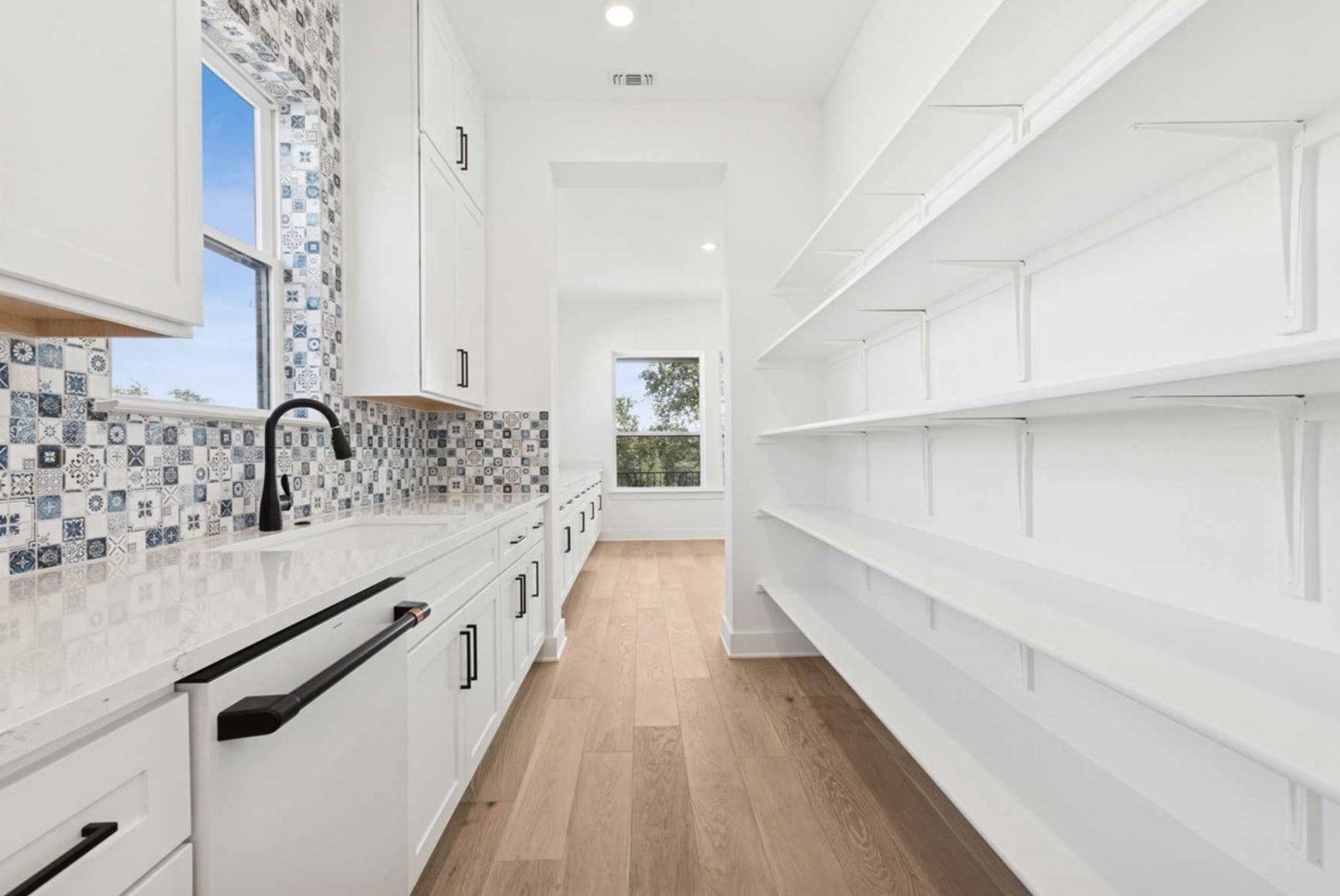 439 Vail River Road Dripping Springs, TX 78620 - Photo 6 of 20 a large white kitchen with a sink and cabinets