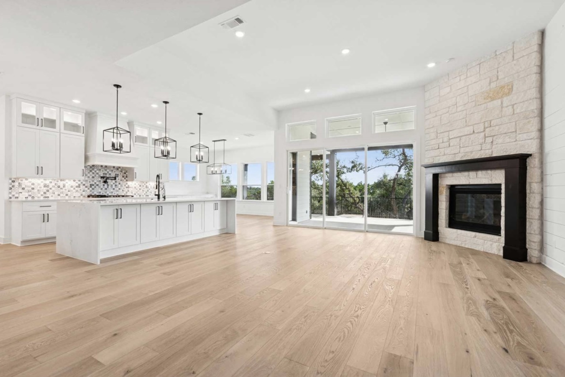 439 Vail River Road Dripping Springs, TX 78620 - Photo 7 of 20 a large white kitchen with kitchen island and stainless steel appliances