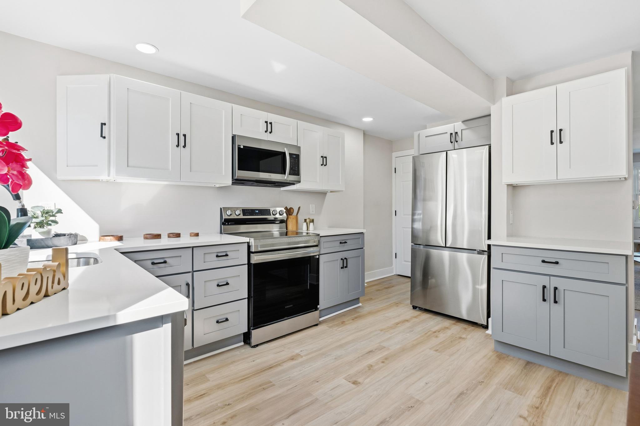 726 Grant Road Folcroft, PA 19032 - Photo 8 of 23 a kitchen with granite countertop a refrigerator stove and wooden floors