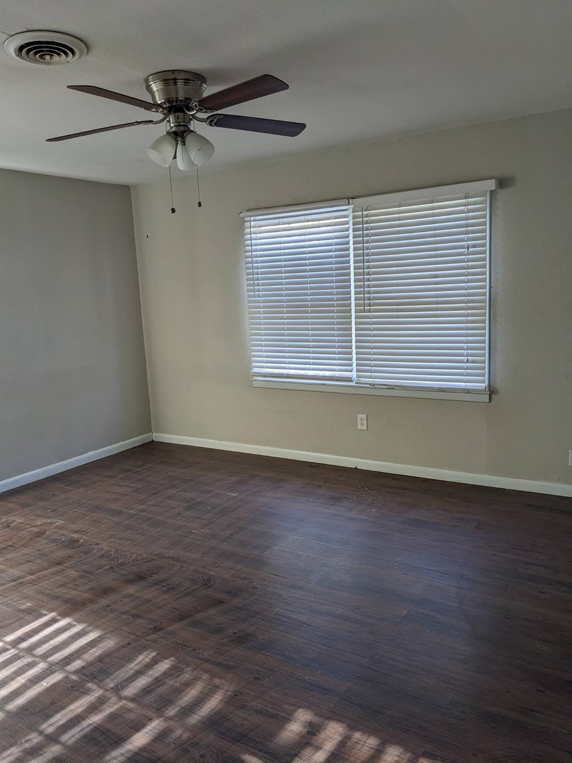 4009 44th Street Lubbock, TX 79413 - Photo 12 of 15 an empty room with wooden floor fan and windows