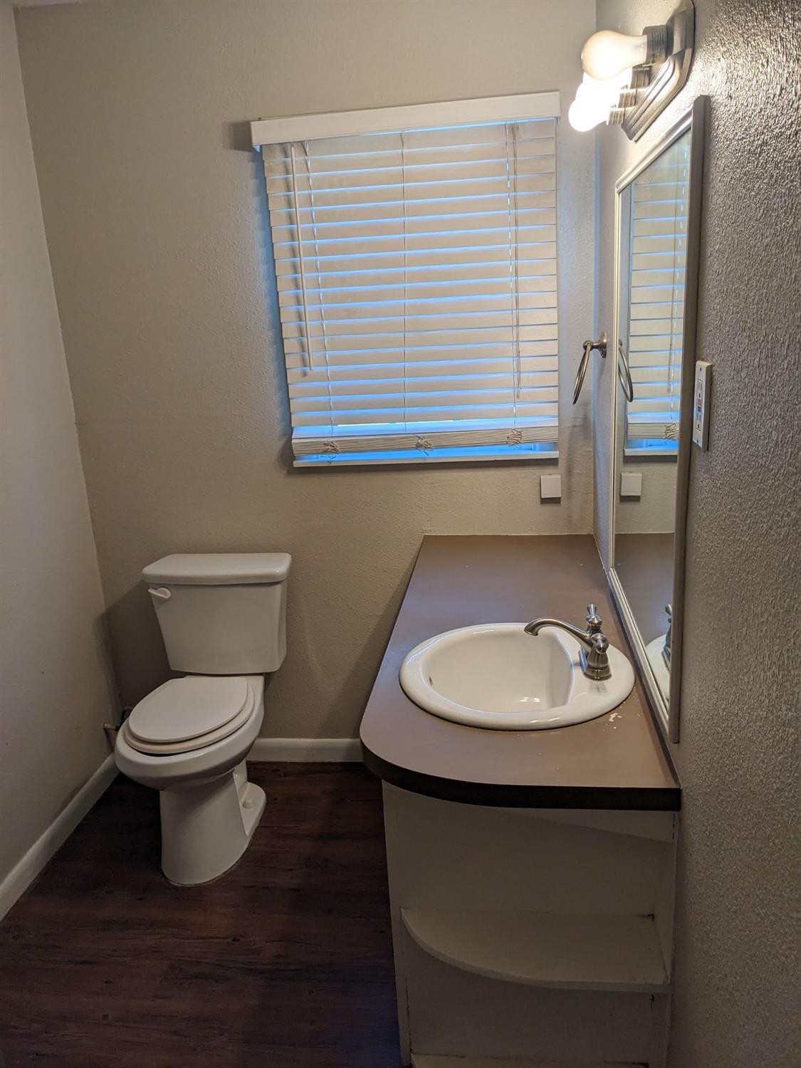 4009 44th Street Lubbock, TX 79413 - Photo 15 of 15 a bathroom with a toilet sink and mirror