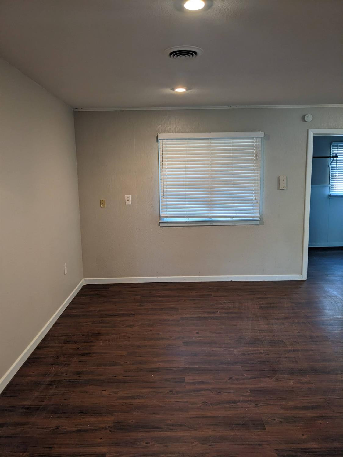 4009 44th Street Lubbock, TX 79413 - Photo 3 of 15 a view of an empty room with wooden floor and a window