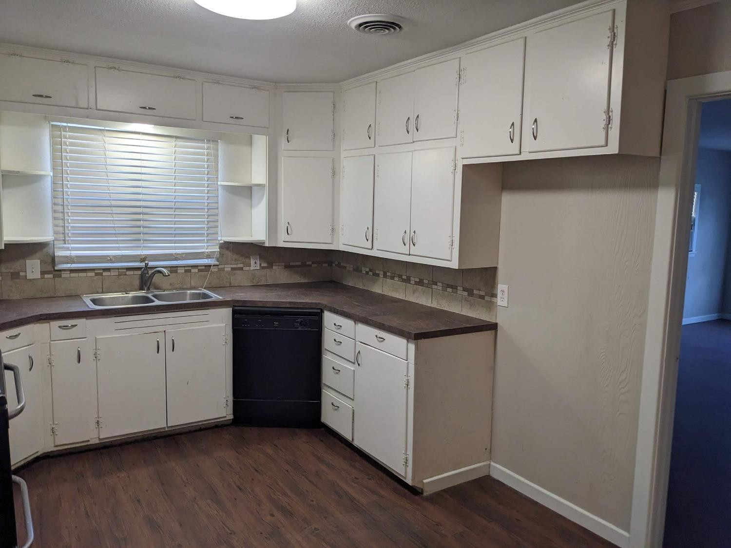 4009 44th Street Lubbock, TX 79413 - Photo 7 of 15 a kitchen with granite countertop white cabinets and a sink