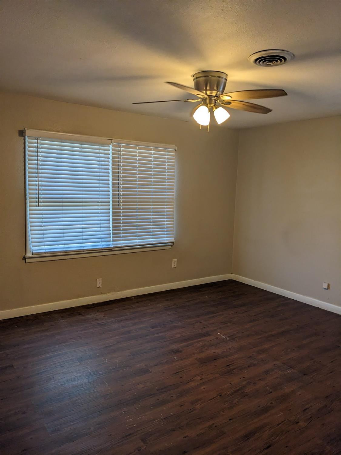 4009 44th Street Lubbock, TX 79413 - Photo 9 of 15 a view of an empty room with wooden floor and a window